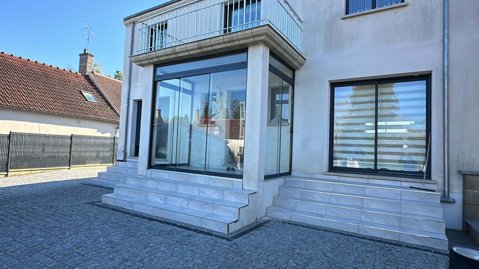 Véranda d'angle en verre pliant sur-mesure